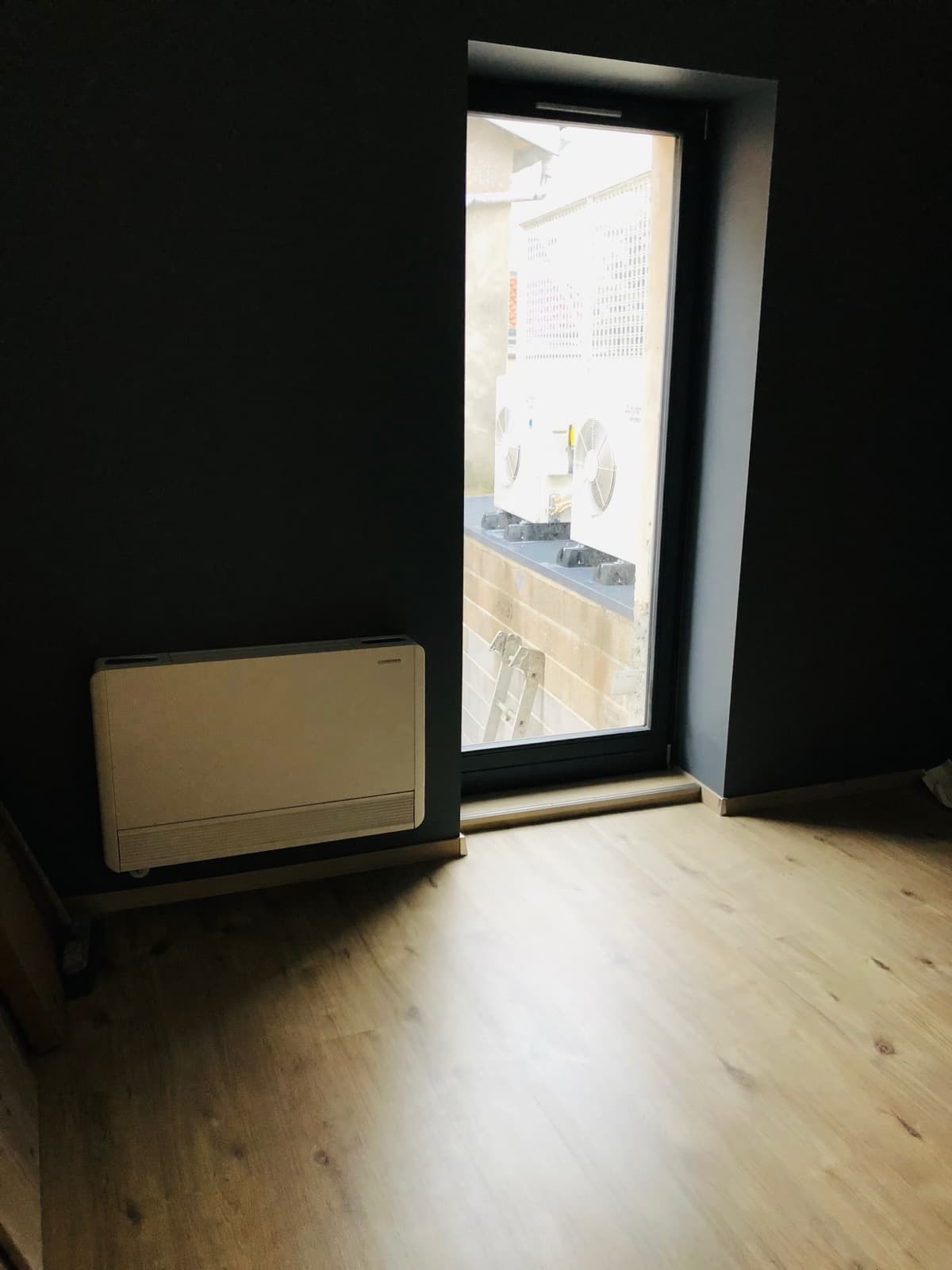 Unité intérieure murale et unité extérieure vues depuis une chambre