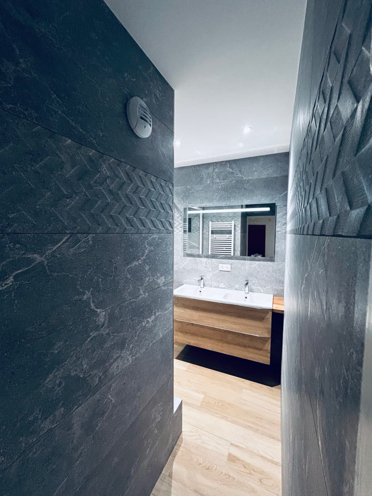 Couloir menant à une salle de bain avec double vasque en bois